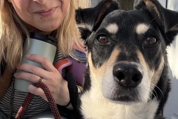 A woman and her black, white, and tan dog getting ready to head to work for the day.