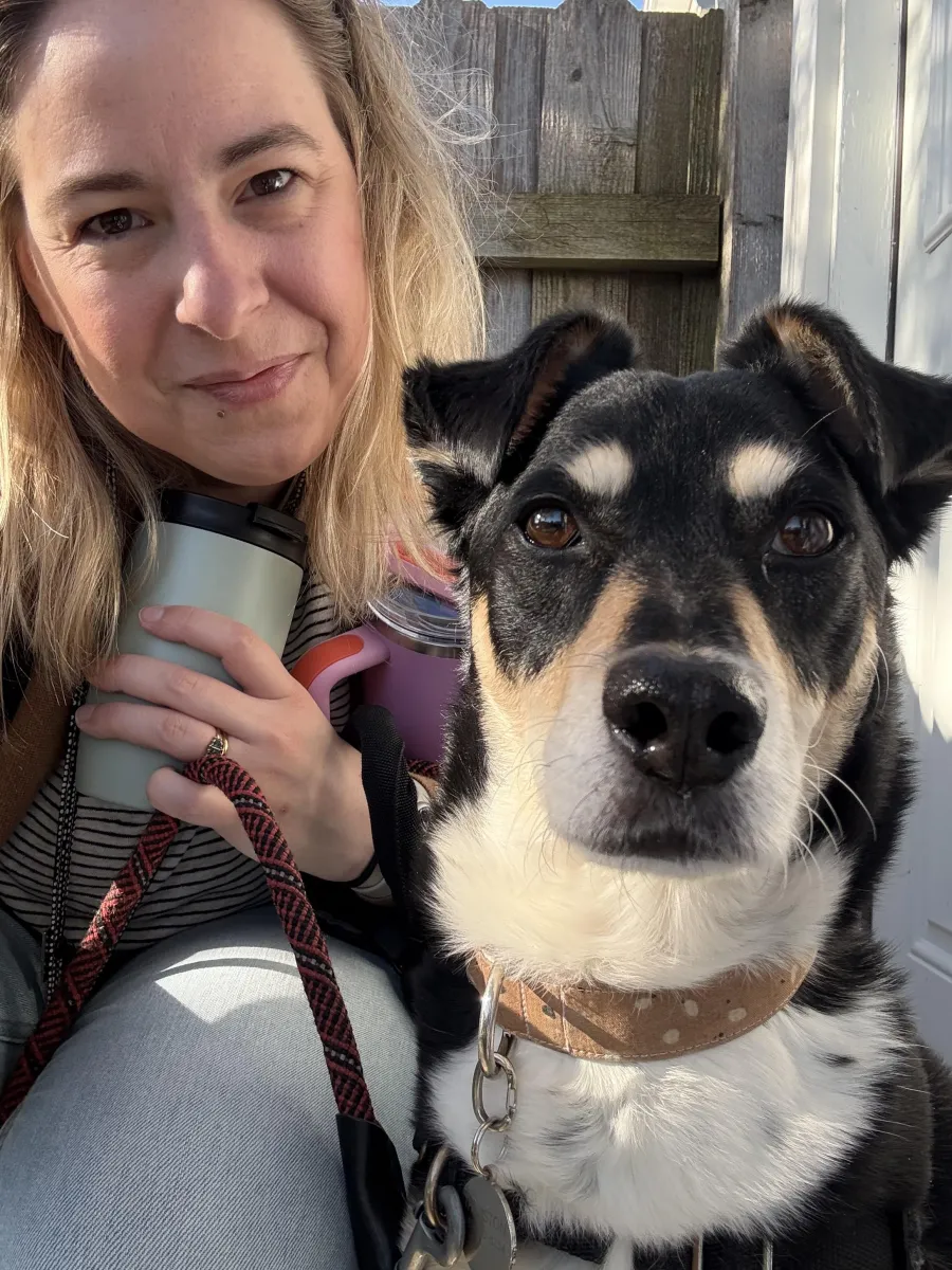 A woman and her black, white, and tan dog getting ready to head to work for the day.